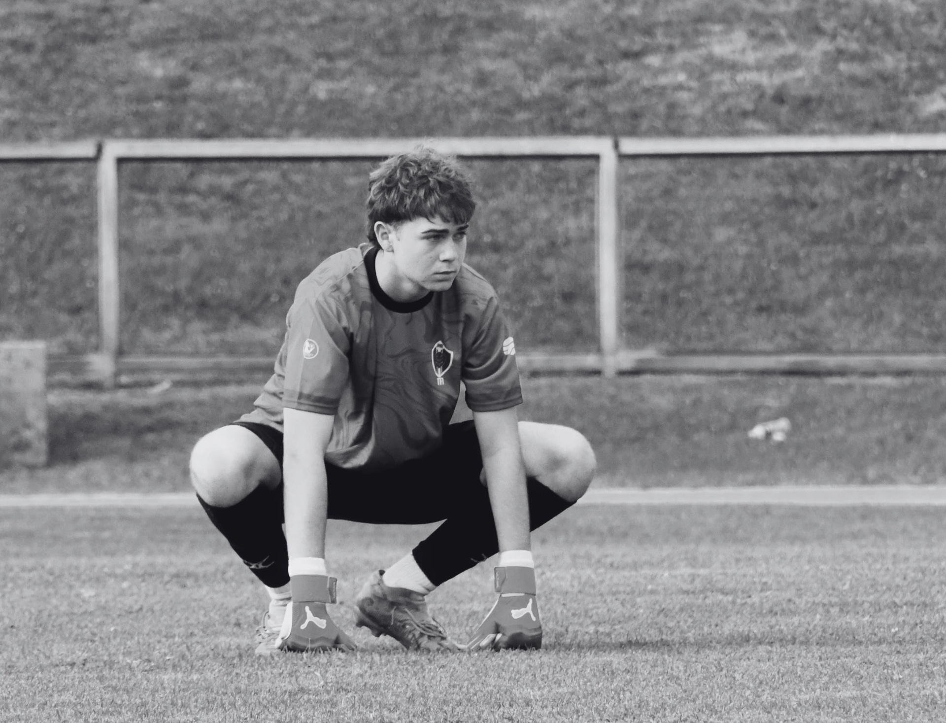 Jason crouched in goalkeeper set position, alone on the pitch